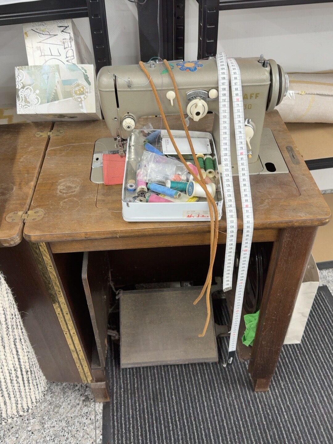 Traditionelle Nähmaschine mit Maßband und Garn